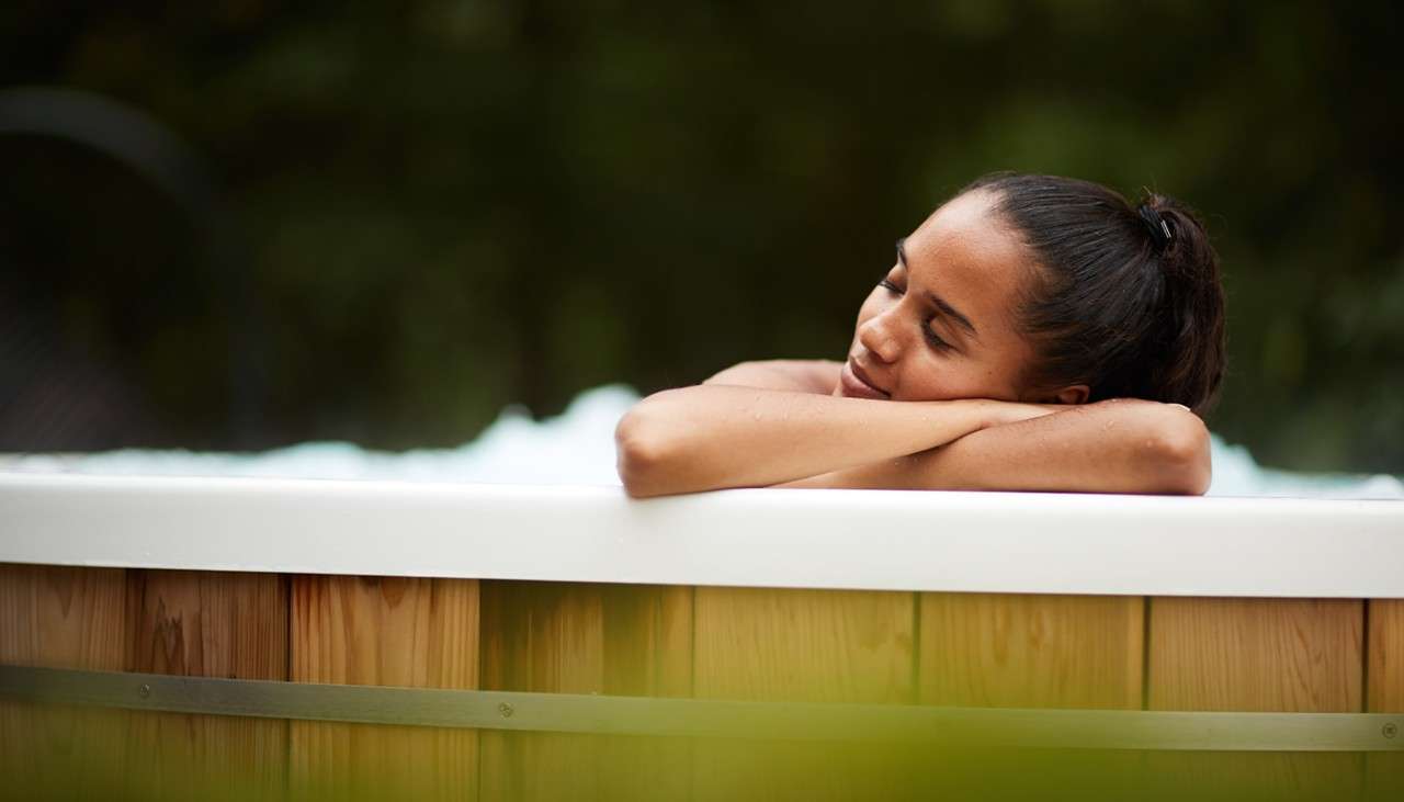 A woman relaxing in the Aqua Sana hot tub.