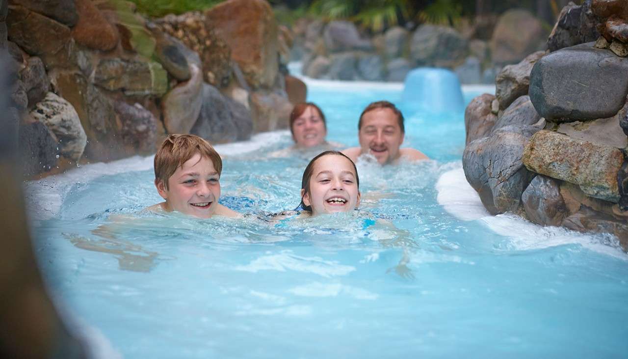 Family splashing down the Wild Water Rapids at the Subtropical Swimming Paradise