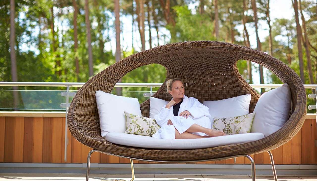 Woman lounging in a large comfortable egg chair 