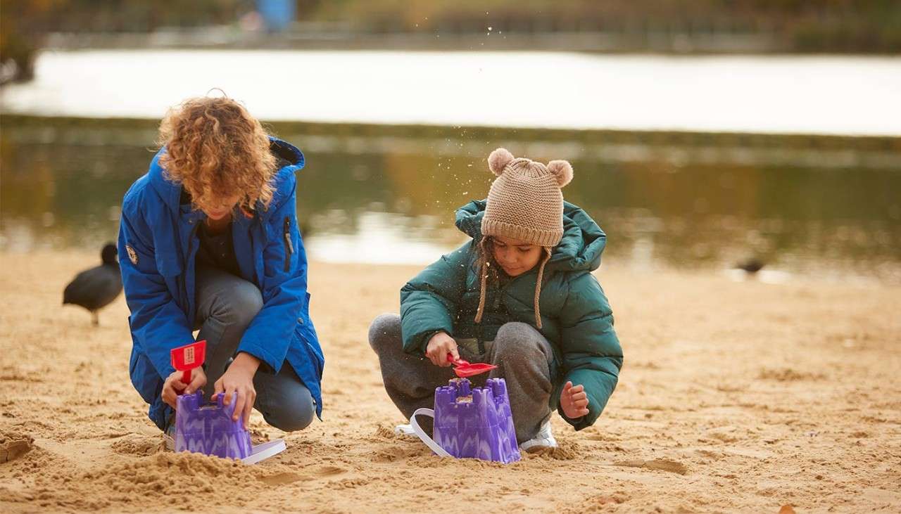 Children making sand castles on the beach.