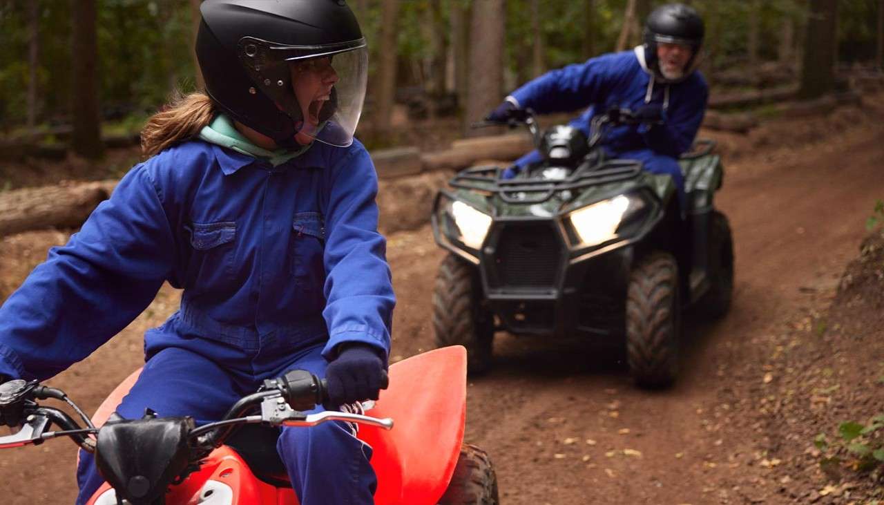 A brother and sister on quad bikes.