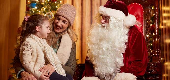 A little girl sat with her mum whilst visiting Santa.