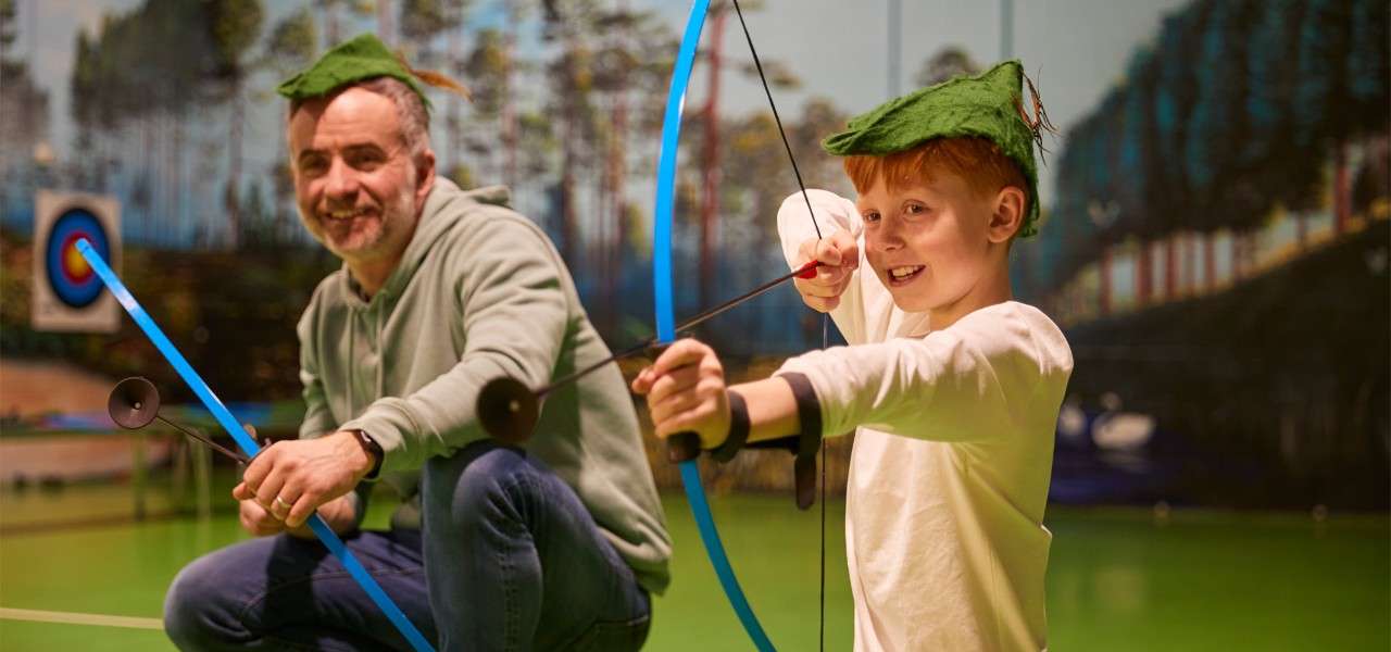 Young boy and a parent taking part in Archery - Little Outlaws